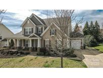 Charming two-story home featuring a covered porch, well-manicured lawn, and attached two-car garage at 15125 Skypark Dr, Huntersville, NC 28078