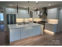 Modern kitchen featuring white cabinets, stainless steel appliances, and a large island with quartz countertops at 160 Belfry Loop, Mooresville, NC 28117