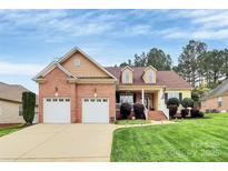 Charming two-story home with a brick facade, attached two-car garage, manicured lawn and inviting front porch at 1674 Wakefield Way, Rock Hill, SC 29730