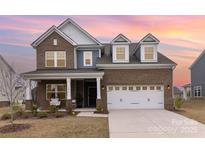 Charming brick home with a two-car garage and covered front porch at 1854 Carrollton Dr, Indian Trail, NC 28079