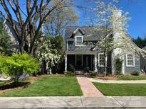 Charming home with brick walkway leading to a covered porch and lush front yard at 203 S Washington St, Monroe, NC 28112