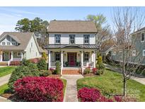 Charming two-story home featuring a welcoming front porch and beautiful landscaping with colorful shrubs at 478 Beaty St, Davidson, NC 28036