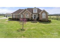 Beautiful brick home with a well-manicured lawn and lovely landscaping details at 6808 Austin Grove Church Rd, Marshville, NC 28103