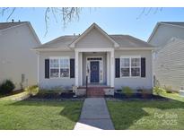 Charming single story home featuring a well maintained lawn and inviting blue front door at 8722 Arrowhead Place Ln, Cornelius, NC 28031
