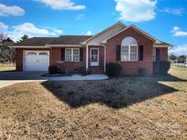 Charming brick home with well-maintained lawn, attached garage, and classic architectural details at 898 Sage Field Ln, Lincolnton, NC 28092