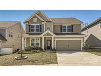 Charming two-story home with a welcoming front porch, a well-manicured lawn, and a two-car garage at 120 Hornbeam Ln, Mooresville, NC 28117
