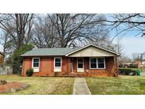 Charming brick home featuring a well-maintained lawn, red shutters, and cozy front porch at 3000 Dalecrest Dr, Charlotte, NC 28269