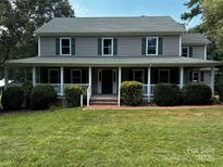 Charming two-story home features a large front porch, well-maintained lawn and mature trees at 3424 Red Fox Trl, Matthews, NC 28104