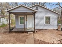 Charming single-story home featuring a covered porch, neutral siding, and a well-maintained yard at 402 N Boyd St, Gastonia, NC 28052