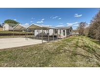 Cozy home featuring dual carport parking, with green lawn space and blue sky backdrop at 4285 Dc Dr, Concord, NC 28025