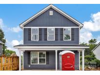 Two-story home featuring blue siding, black shutters, and white trim details, with a covered porch at 513 Harrel St, Salisbury, NC 28144