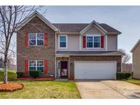 Charming two-story home with brick accents, attached two-car garage, and a well-manicured lawn at 10071 Highland Creek Cir, Indian Land, SC 29707