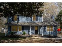 Charming blue two-story home with black shutters, covered porch, and mature landscaping at 1024 Eaglewood Ave, Charlotte, NC 28212