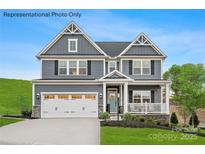 Two-story home with a front porch, two-car garage, and light blue siding at 2016 Bramble Hedge Rd # 3277, Indian Trail, NC 28079