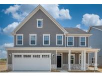Charming two-story home with gray siding, white trim, a front porch, and an attached two-car garage at 2016 Bramble Hedge Rd # 3277, Indian Trail, NC 28079