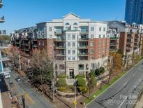 Beautiful condo building with brick and white facade, balconies, and manicured landscaping, in a desirable location at 300 W 5Th St # 344, Charlotte, NC 28202