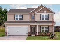 Charming two-story home featuring a two-car garage and neutral siding, complemented by dark shutters and a welcoming front porch at 5614 Skinny Dr, Charlotte, NC 28215