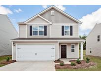 Charming two-story home with a two-car garage, classic black shutters, and neutral siding at 5704 Skinny Dr, Charlotte, NC 28215