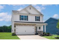 Two-story home featuring stone accents, white siding, a two-car garage and black shutters at 5704 Skinny Dr, Charlotte, NC 28215