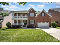 Charming red brick home features a welcoming double porch and a well-maintained lawn at 615 Vega Nw St, Concord, NC 28027