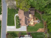 Aerial view of property showing multiple decks, backyard firepit, lush landscaping, and long driveway at 9009 Stourbridge Dr, Huntersville, NC 28078