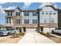 Charming townhome exterior with stone accents, attached garage, and inviting curb appeal at 108 Helm Ln, Mooresville, NC 28117