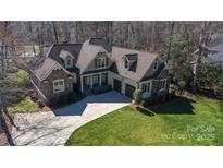 Aerial view of the stunning home featuring a stone facade, beautiful landscaping, and a long driveway at 147 Pearl Bay Dr, New London, NC 28127