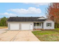 Charming home featuring a two-car garage and a well-maintained front yard with mature trees at 155 Country Ln, Mooresville, NC 28115