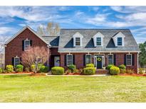 Stately brick home featuring a manicured lawn, mature landscaping, and a welcoming front entrance at 1790 Faires Rd, Rock Hill, SC 29730