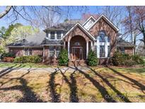 Charming brick home featuring a well-manicured lawn, arched entryway, and lush landscaping at 2430 Berkshire Dr, Salisbury, NC 28146