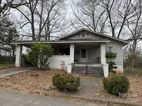 Charming single-story home with a cozy covered porch and a quaint front yard, nestled amongst mature trees at 305 Suttle St, Shelby, NC 28150