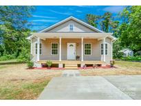 Charming home featuring a welcoming front porch with elegant white columns and a beautifully landscaped front yard at 406 White Store Rd, Wadesboro, NC 28170