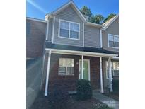 Charming townhome featuring a brick facade, complemented by neutral siding and a cozy covered porch at 9130 Charminster Ct, Charlotte, NC 28269