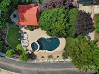 Aerial view of pool with surrounding patio, gazebo and lush landscaping creating a private backyard oasis at 1569 Benjamen Latrobe Cir, Fort Mill, SC 29708