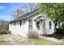 Charming two-story home with white siding, a covered entryway, and mature trees at 234 S Ervin Ave, Newton, NC 28658