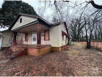 Modest home with a covered front porch and neglected yard at 2501 Booker Ave, Charlotte, NC 28216