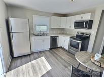 Well lit kitchen with stainless steel appliances and white cabinets and granite countertops at 507 E Maple Ave, Gastonia, NC 28054