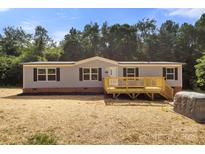 Charming single-story home with a cozy front porch, set against a backdrop of lush trees at 141 Lakewind Dr, Mooresville, NC 28115