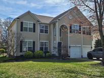 Charming two-story home with a well-manicured lawn, lush landscaping, and a two-car garage, creating a welcoming curb appeal at 14117 Hiawatha Ct, Huntersville, NC 28078