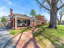 Charming brick home with a cozy front porch, brick walkway, and a lush green lawn at 1623 Geneva Ct, Charlotte, NC 28209