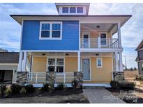 Charming two-story home with blue and yellow siding, inviting front porch, and stone accents at 255 Luray Way # 442, Rock Hill, SC 29730