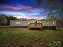 Charming one-story home with a well-kept lawn, deck, and inviting entrance, creating a welcoming curb appeal at 35494 Dry Rd, Albemarle, NC 28001