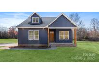 Charming single-Gathering home boasting a well-manicured lawn, complemented by a covered front porch and stylish blue siding at 4005 Miller Rd, Salisbury, NC 28147