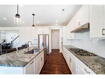 Bright kitchen features white cabinets, stainless steel appliances, granite countertops, and hardwood floors at 4208 Stream Dale Nw Cir, Concord, NC 28027