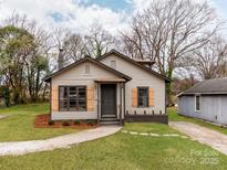 Charming home featuring a quaint front yard, fresh landscaping, and light gray siding with dark gray trim at 507 N Oakland St, Gastonia, NC 28052