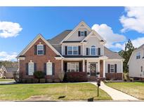 Charming two-story home featuring a combination of brick and siding, complemented by a well-manicured lawn and lush landscaping at 1736 Townsend Ln, Rock Hill, SC 29730