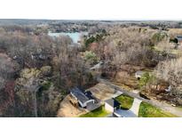 Stunning aerial view of property near the lake, featuring a manicured lawn, detached garage, and beautiful surroundings at 118 Alfara Ln, Troutman, NC 28166