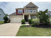 Charming two-story home with a manicured lawn, attached garage, and inviting front porch at 16839 Cozy Cove Rd, Charlotte, NC 28278