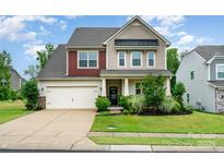Charming two-story home featuring a two-car garage, a well-manicured lawn, and a welcoming front porch at 16839 Cozy Cove Rd, Charlotte, NC 28278