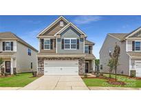 Two-story home featuring stone accents, a two-car garage and neutral color palette at 1816 Otter Perch Ln, Fort Mill, SC 29715